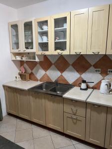 a kitchen with wooden cabinets and a sink at Renome in Petrovac na Moru