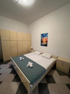 a bedroom with a large bed with towels on it at Renome in Petrovac na Moru
