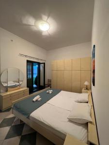 a bedroom with a large bed with two towels on it at Renome in Petrovac na Moru