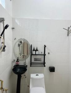 y baño con lavabo, aseo y espejo. en La Wood Homestay near Kuala Besut Jetty en Kampung Kuala Besut