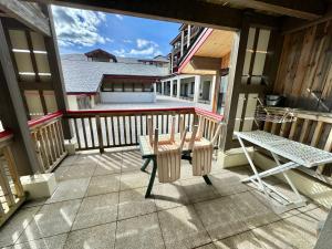eine Terrasse mit Tisch und Stühlen auf einem Balkon in der Unterkunft Joli studio en montagne in Font Romeu Odeillo Via
