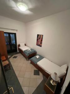 a small room with two beds and a window at Renome in Petrovac na Moru