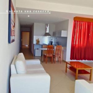 ein Wohnzimmer mit einem weißen Sofa und einer Küche in der Unterkunft Hotel Vista in Praia