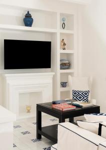 a living room with a tv and a fireplace at Boutique Hotel Casa Mariantonia in Anacapri