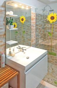 baño con lavabo y ducha con girasoles en Appartement d'une chambre avec jardin amenage et wifi a Baie Mahault, en Baie-Mahault