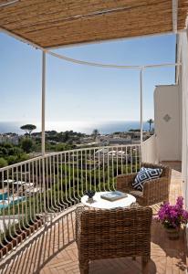 a patio with a table and chairs on a balcony at Boutique Hotel Casa Mariantonia in Anacapri