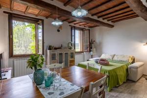 a living room with a table and a couch at Pociano 1863 - Country House with Stunning view of Siena in Monteroni dʼArbia