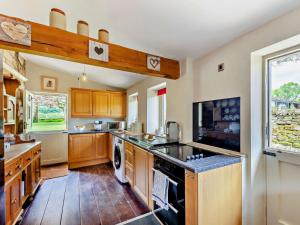 uma grande cozinha com armários de madeira e uma grande janela em 4 Bed in Skipton 95023 em Foulridge