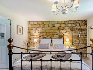 uma cama num quarto com uma parede de pedra em 4 Bed in Skipton 95023 em Foulridge