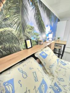 um quarto com uma cama e um mural de palmeiras em Nid douillet pour amoureux avec jacuzzi privatif em La Valette-du-Var