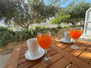 due bicchieri di succo d'arancia su un tavolo di legno di Guest House Kovacevic a Hvar
