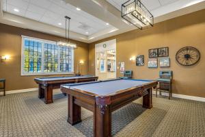 Una sala de billar con dos mesas y un reloj. en Ocean View Beach Club --- 2 Middlesex Drive, en Frankford