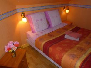 ein Schlafzimmer mit einem Bett mit einer Vase aus Blumen auf dem Tisch in der Unterkunft Family DELCOUR in Mailly-Maillet