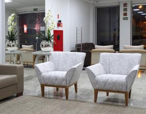 a room with two chairs and tables in a store at BITTI HOTEL Aracruz by Samba in Aracruz