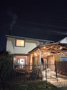 a house with a fence in front of it at night at Casa Rústica Sureña Grande in Valdivia