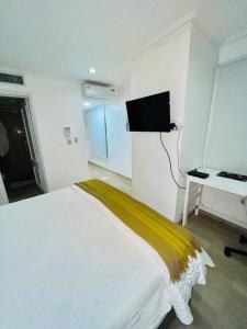 biała sypialnia z łóżkiem i biurkiem w obiekcie Spectacular Condominium between the city and the sea w mieście Santo Domingo