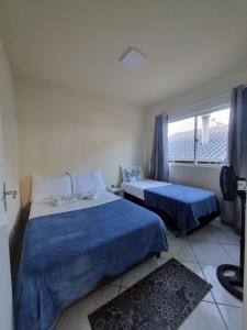 een slaapkamer met 2 bedden en een raam bij Residencial Cristina's-Apartamentos de 2-3 Quartos equipados com WiFi Garagem-Excelente Localização in Lages