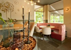 a living room with a table and a dining room at Hotel Bergrust in Bemelen