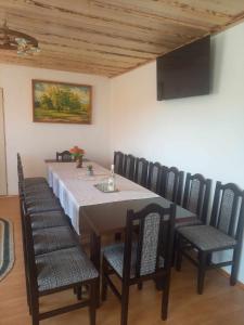 a dining room with a table and chairs and a painting at Narcise kulcsoshaz in Joseni +17 photos