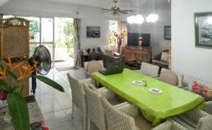 a living room with a green table and chairs at 3 bedrooms house at Grand Baie 500 m away from the beach with private pool enclosed garden and wifi in Grand-Baie