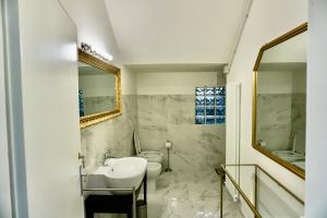 ein Badezimmer mit Waschbecken, Toilette und Spiegel in der Unterkunft Casale Mongiusti 1961 in Musano + 31 Fotos