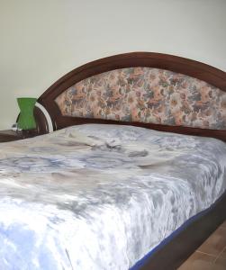 a bed with a wooden headboard with a blanket on it at 2 bedrooms apartement at Grand Gaube 200 m away from the beach with sea view furnished terrace and wifi in Grande Gaube