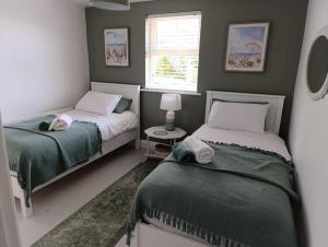 a small bedroom with two beds and a window at Greenhills Cottage -Overlooking Slieve League in Kilcar