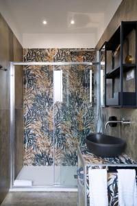 a bathroom with a glass shower with a sink at Trastevere New Luxury Rooms in Rome