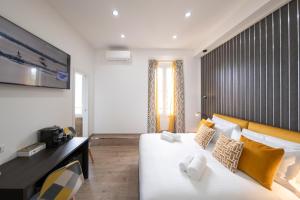 a bedroom with a large white bed with yellow pillows at Trastevere New Luxury Rooms in Rome
