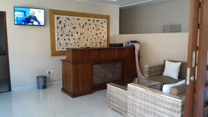 a living room with a fireplace and a tv at Nyaman Guest House in Sanur