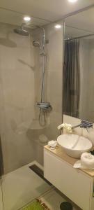 uma casa de banho branca com um lavatório e um chuveiro em Light Brown Central Apartment em Aveiro