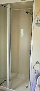 um chuveiro com uma porta de vidro na casa de banho em J.R. Holiday Homes em Clacton-on-Sea