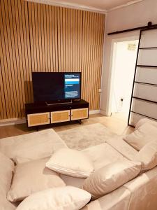 uma sala de estar com um sofá e uma televisão de ecrã plano em Japandi themed London Apartment em Thornton Heath