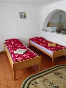 a bedroom with two beds and a mirror at Narcise kulcsoshaz in Joseni
