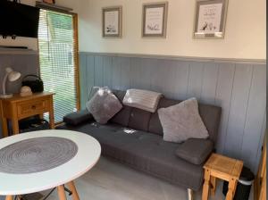 - un salon avec un canapé et une table dans l'établissement Hedgehog Lodge, à Colwall