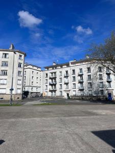 an empty street in front of two white buildings at L Appartement - Siam vue Capucins in Brest