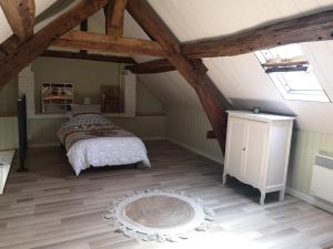Cette chambre mansardée comprend un lit et un tapis. dans l'établissement Maison Familiale à 5 min de LaON, à Vorges