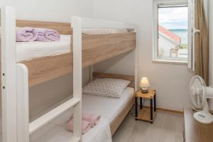 a small bedroom with bunk beds with a window at Apartmani Danijel in Nin