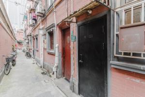 an alley with a black door on a red brick building at Shanghai Hills& XING 479 B&B in Shanghai