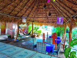 an outdoor dining area with a thatched table and chairs at Hostal Y Restaurante El Escondite San Ramón in Ometepe