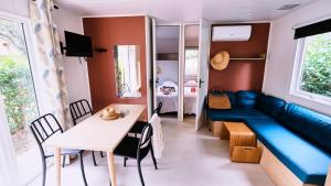 Camping le Relais du Léman في Messery: شقة صغيرة بها أريكة زرقاء وطاولة