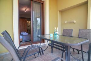 a dining table and chairs on a patio with a room at Homelia in Limenaria