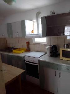 a kitchen with white cabinets and a stove top oven at Narcise kulcsoshaz in Joseni