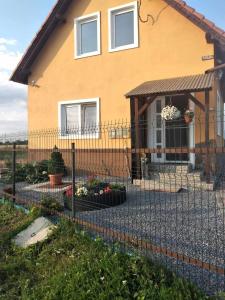 a fence in front of a house with flowers at Narcise kulcsoshaz in Joseni