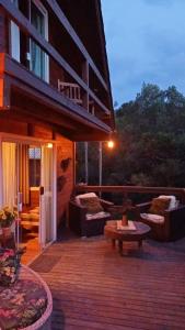 a deck with couches and tables on a building at Hospedagem Cabanas do Lago Urubici in Urubici +21 photos