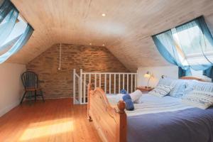 um quarto com uma cama grande num sótão em Domaine de la Blanche Hermine em Plounérin
