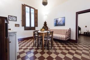 - une cuisine avec une table et des chaises sur un sol en damier dans l'établissement Azienda Agrituristica Tenuta Pizzolungo, à Erice