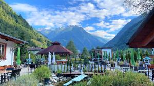 restauracja ze stołami i krzesłami oraz górami w tle w obiekcie IMBACHHORN Pension in den Alpen w mieście Fusch an der Großglocknerstraße