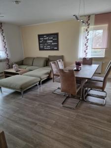 ein Wohnzimmer mit einem Sofa, einem Tisch und Stühlen in der Unterkunft Ferienwohnung "Ernst 1" in Gelenau