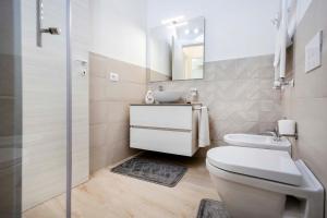 Un baño con inodoro, lavabo y espejo. en Tropea For Family Apartment, en Tropea 33 fotos más